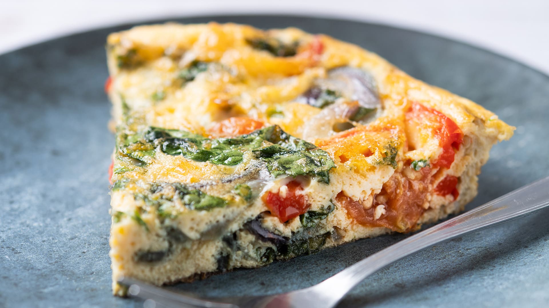 frittata made with spinach tomatoes onion and peppers