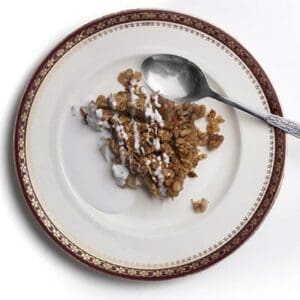 Piece of healthy apple crumble on a plate with yoghurt