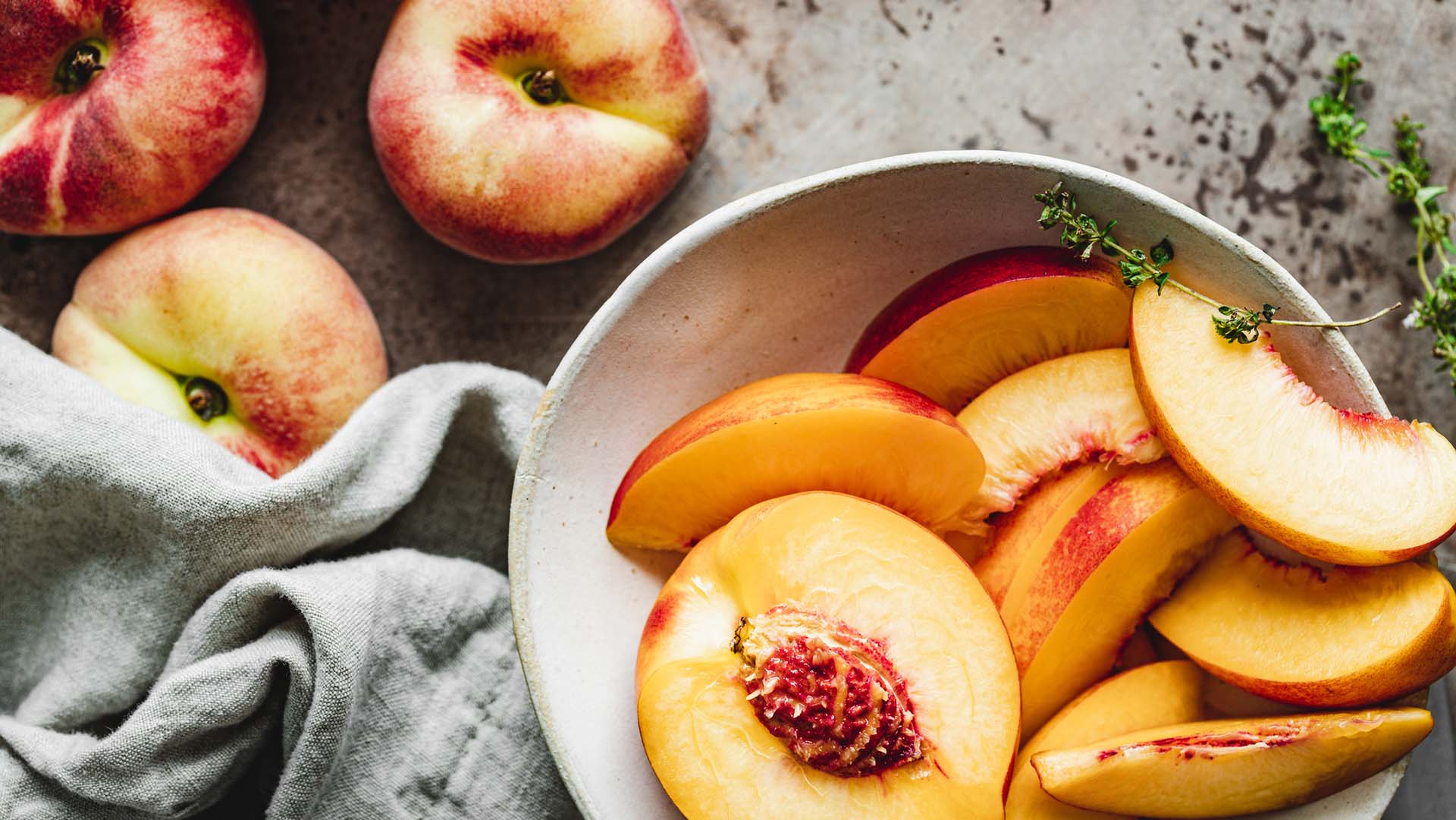 Slices of ripe peaches in a bowl.