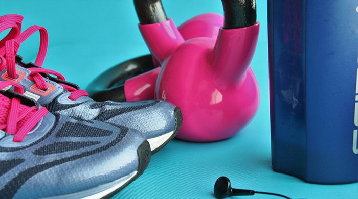 hip-workouts pink kettlebells with trainers and a blue water bottle which you need for workouts