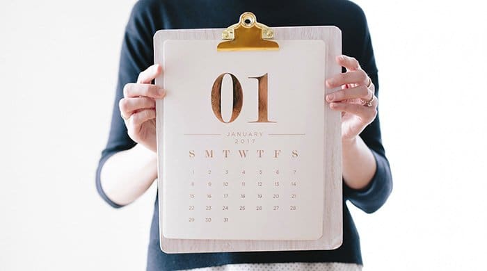 A woman holding a calendar to represent which days in your cycle give you the best skin