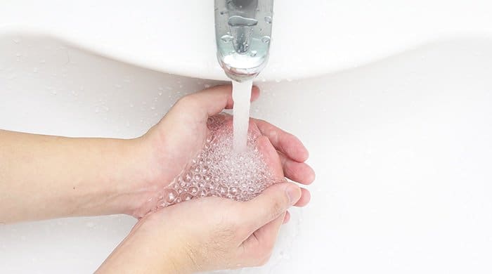 a woman washing her hands after peeing