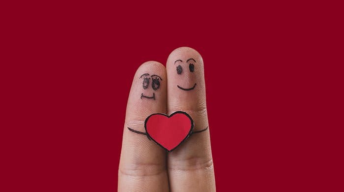 two fingers with a smiley face and heart to represent dating a younger man