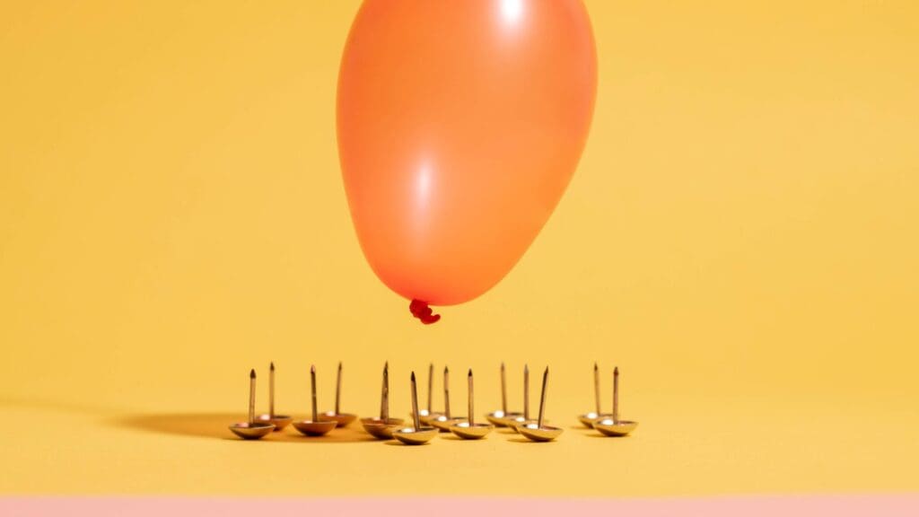 balloon floating above pins on yellow background