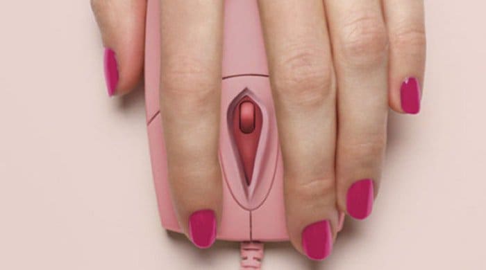 A woman with her hand on a pink mouse to represent a masturbation experience