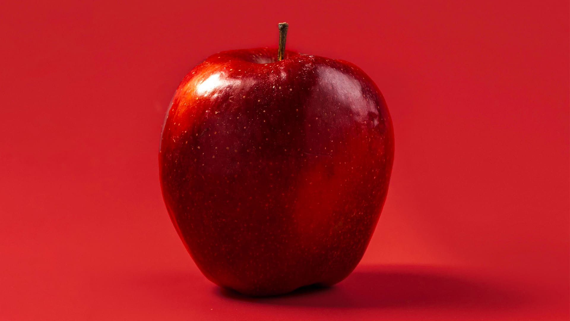 close-up-organic-apple-ready-be-served red apple on red background