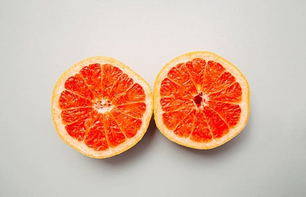 A grapefruit cut in half to represent breasts and nipples that are itchy