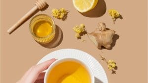 folk flu remedies from arial view, mug of tea with honey, lemon and ginger around it