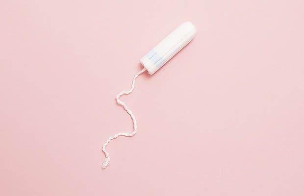 a stuck tampon on a pink background