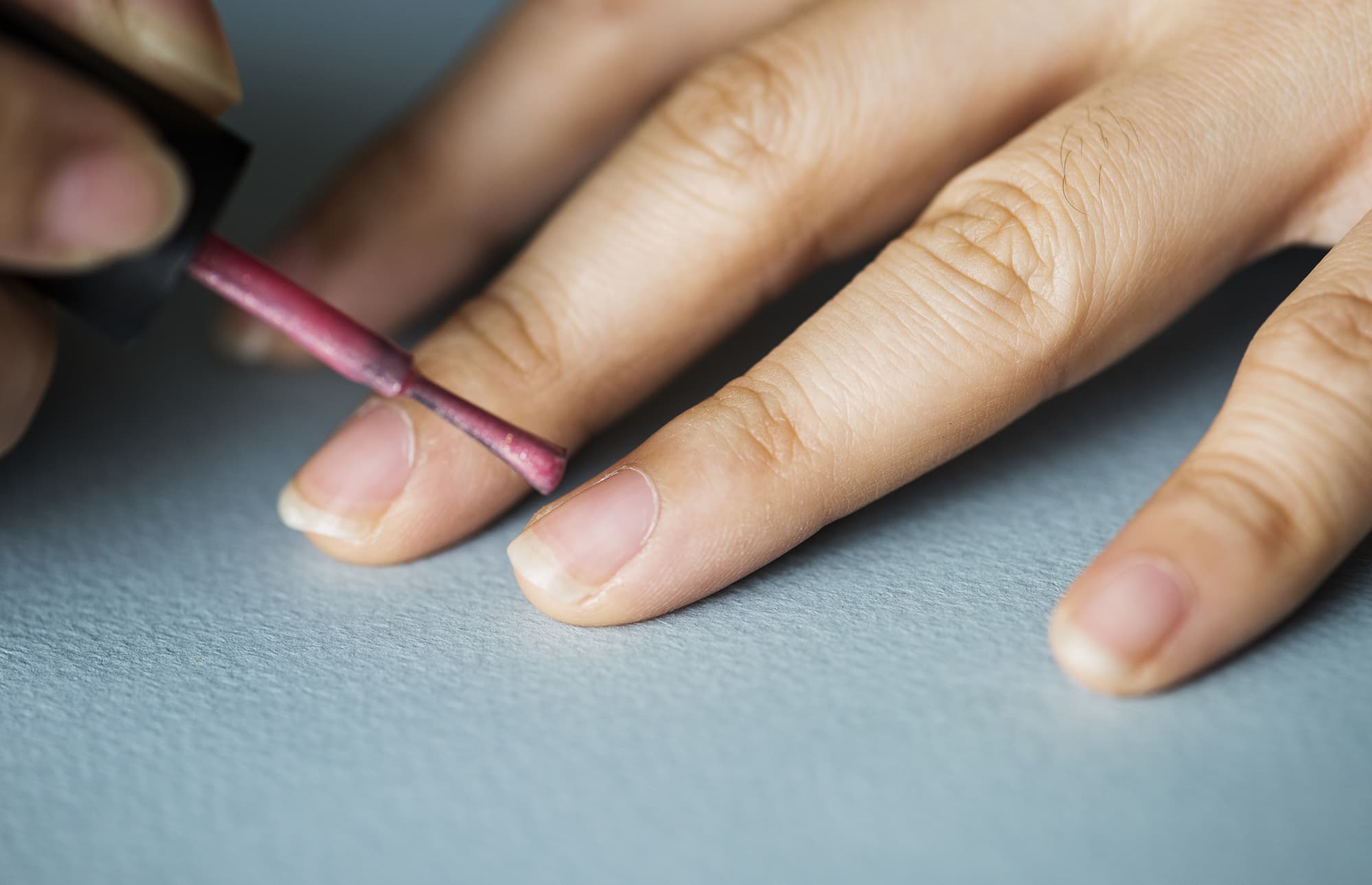 A woman applying polish to stop her nail biting habit
