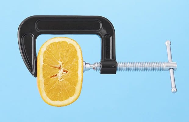 A vice squeezing an orange to represent a tight vagina