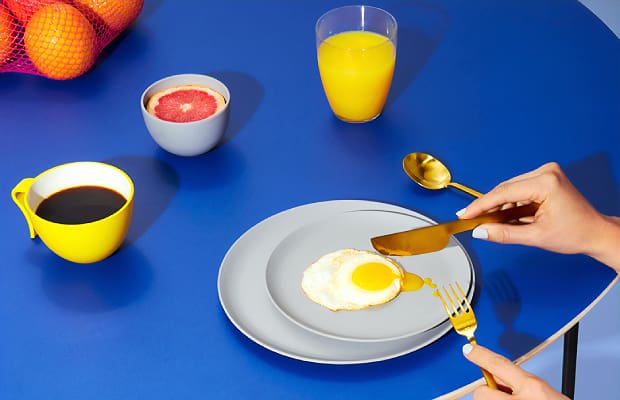 a woman at a blue table using intuitive eating