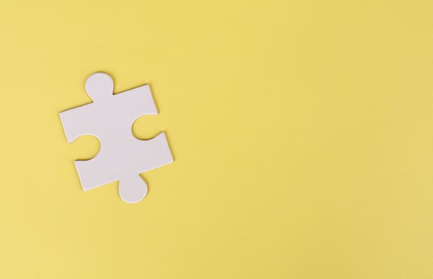 Missing puzzle piece on a yellow background to represent missing someone and how to get through it