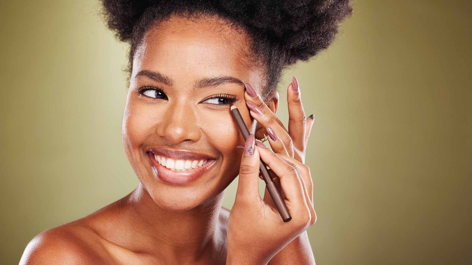 woman applying makeup and eyeliner eye pencil