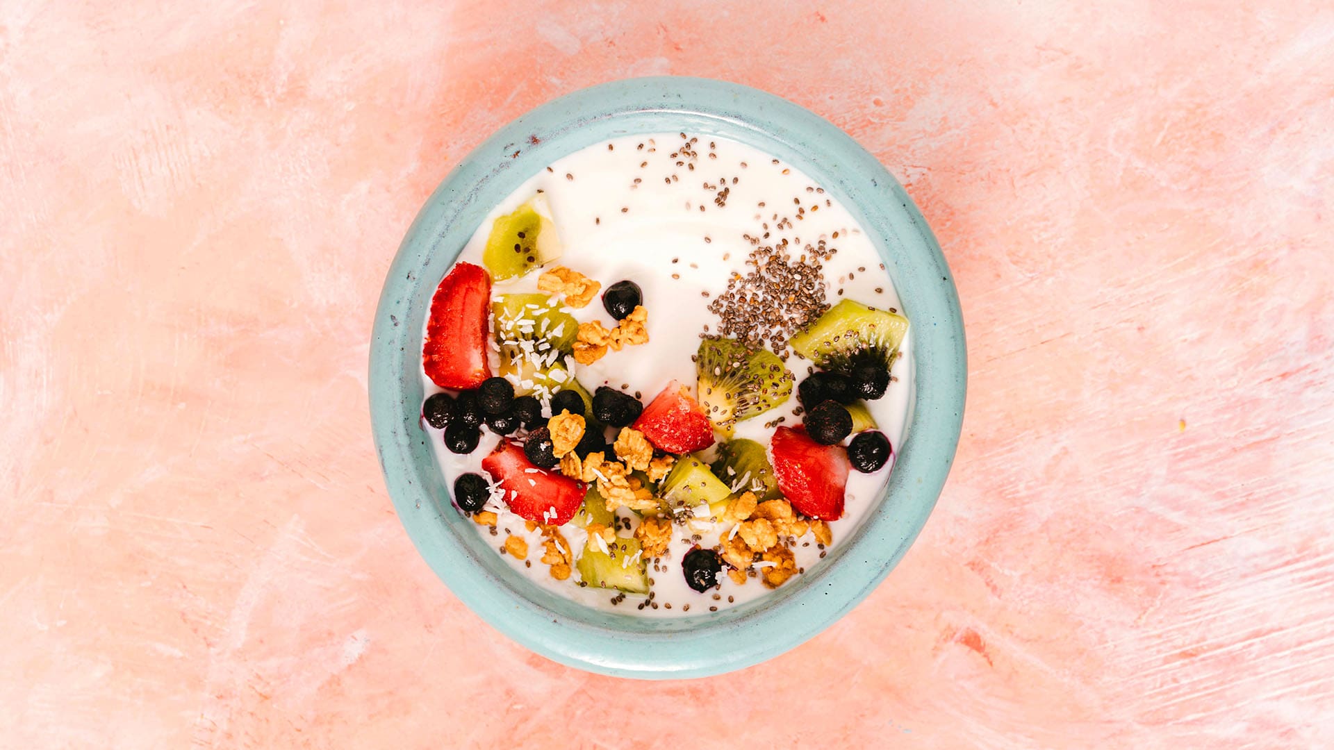 A bowl of cereal with fresh fruit on top
