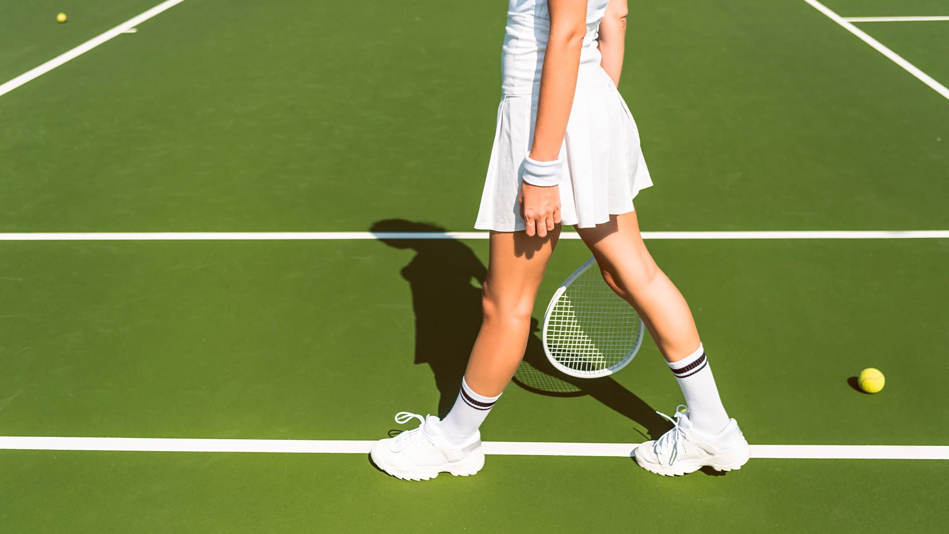 female tennis player in white sportswear with racket on tennis court