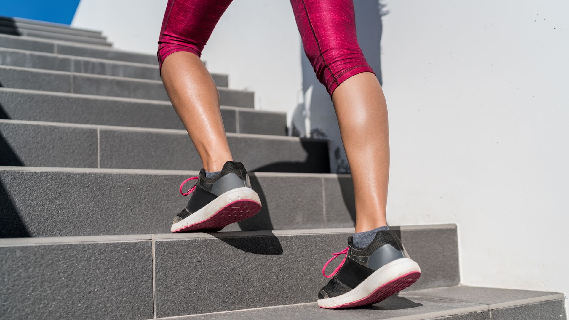 Woman walking upstairs with running shoes