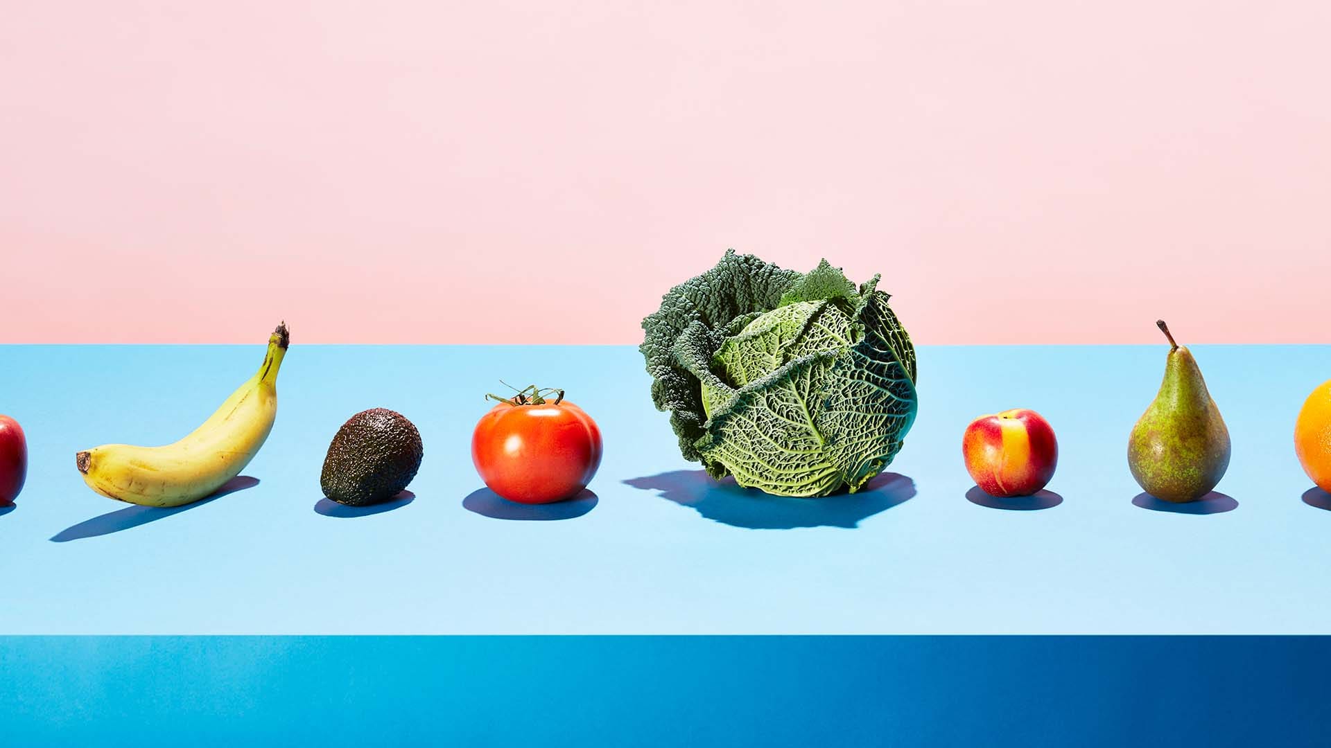 A row of different fruits and vegetables on a table top