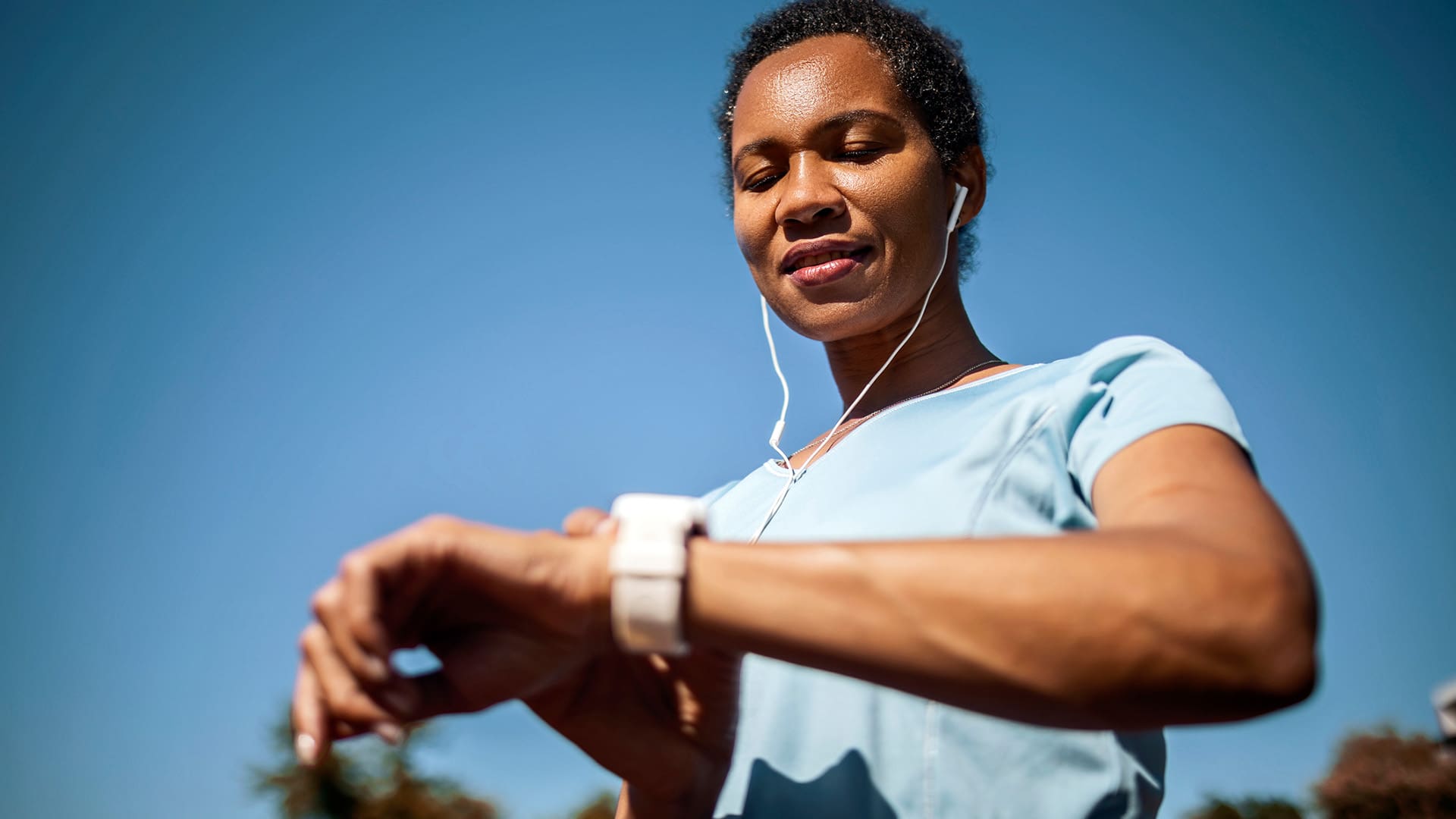 Smiling woman checking heart rate after sports training