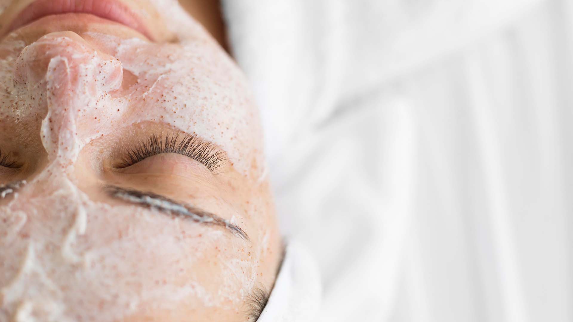 Woman getting a facial or skin treatment on white backdrop