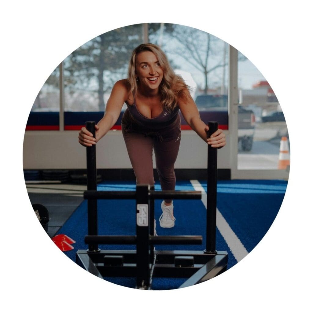 Woman in a gym doing a sled push