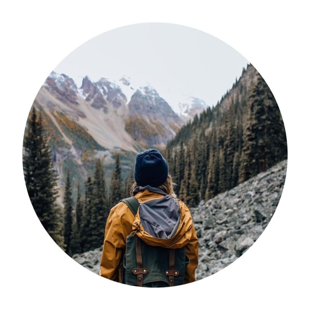 Woman with rucksack in the mountain overlooking a grand mountainous view
