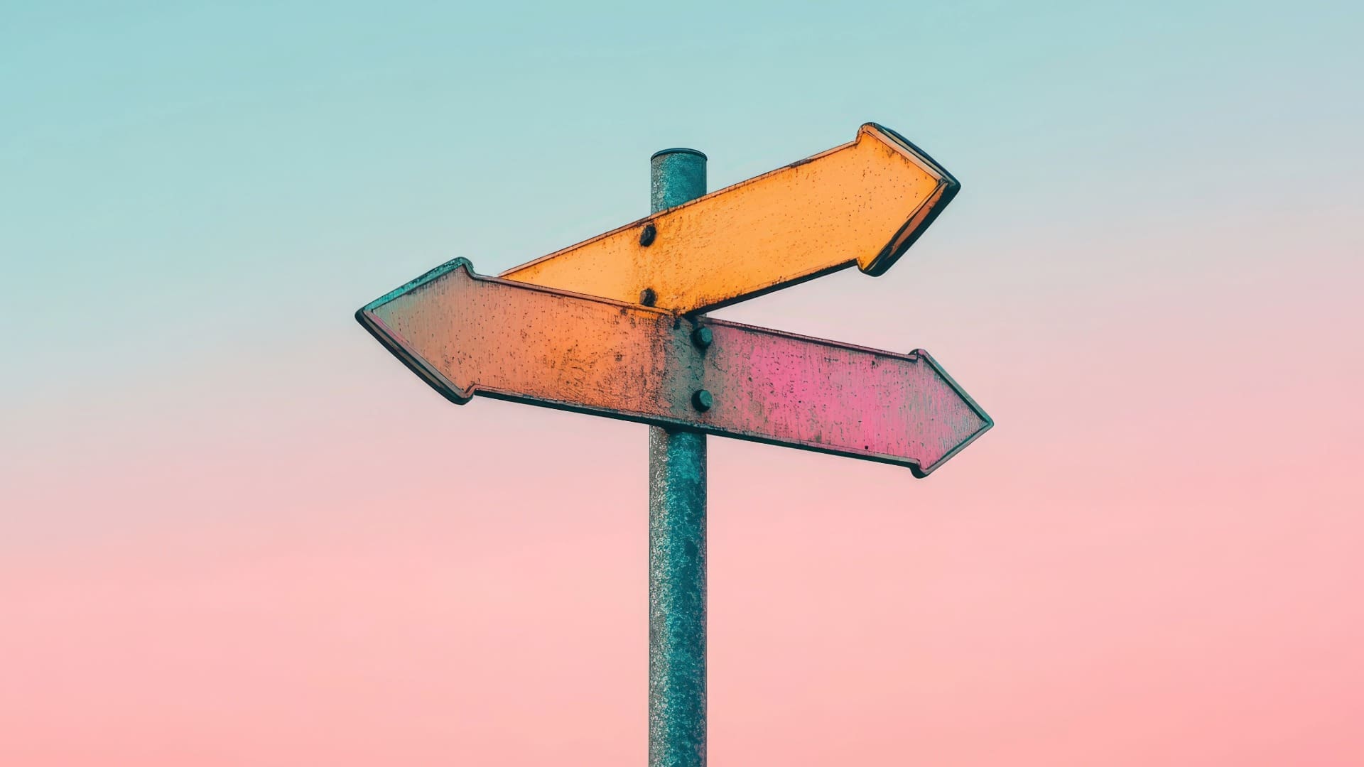 Road sign with arrows pointing in different directions with pink and blue sky