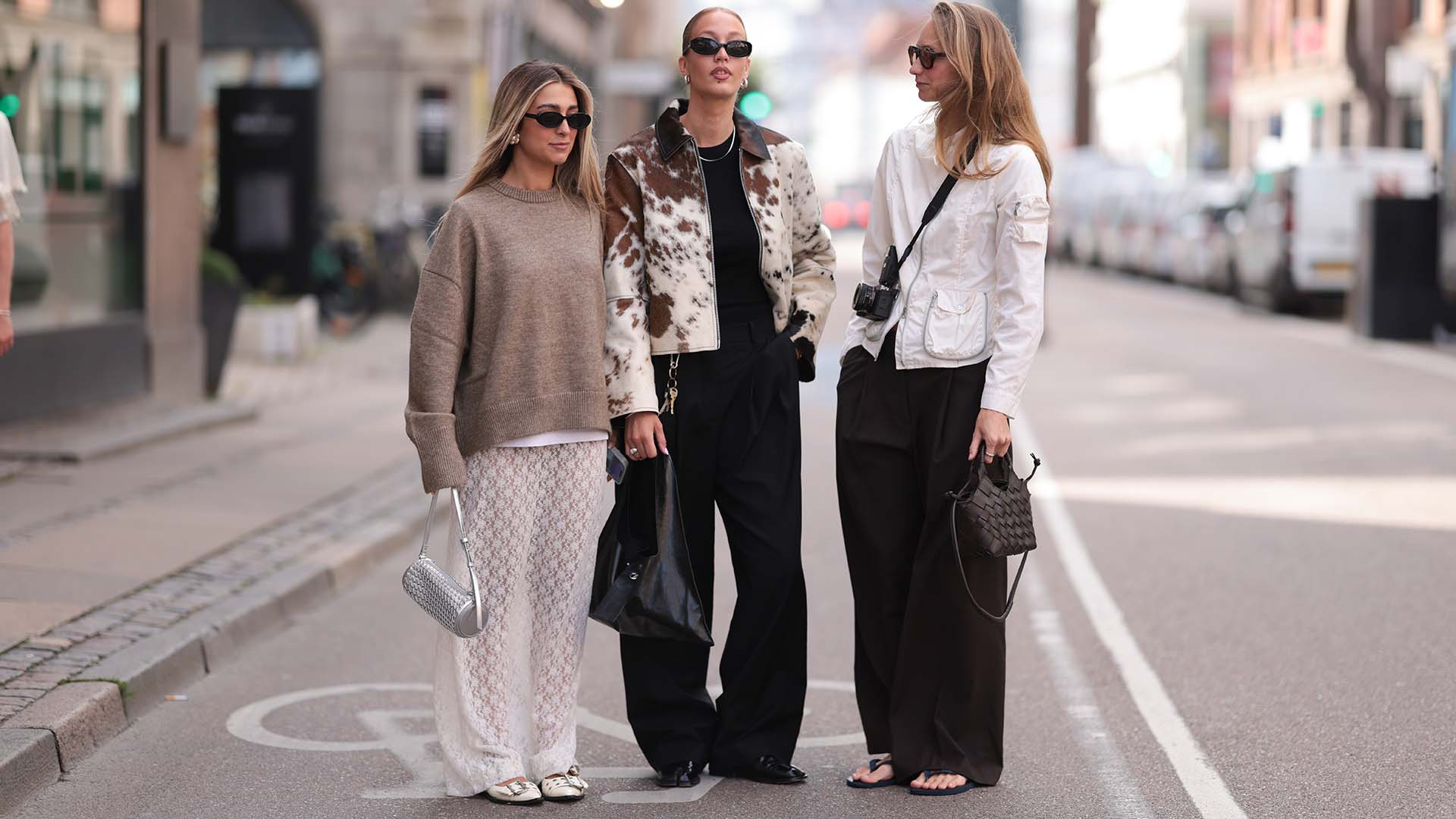 Three stylish women standing in the street