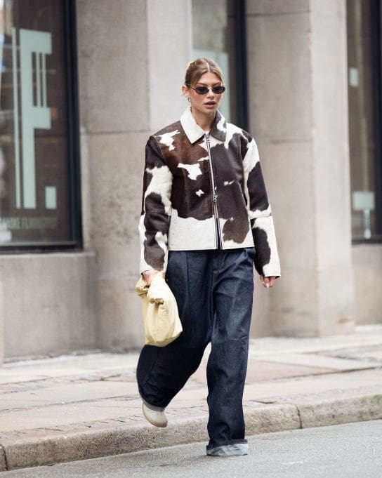 COPENHAGEN, DENMARK - JANUARY 30: Sophia Geiss wears cow print cropped jacket with a zipper, pale yellow bag, blue wide jeans during the Copenhagen Fashion Week Autumn/Winter 2025 on January 30, 2025 in Copenhagen, Denmark. 