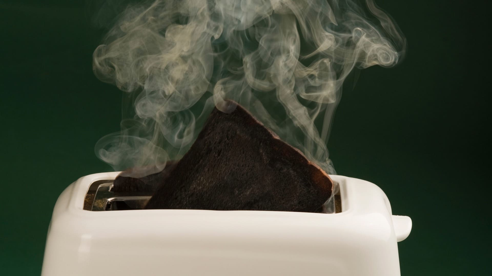 Burnt toast burning with smoke and forgotten in the toaster
