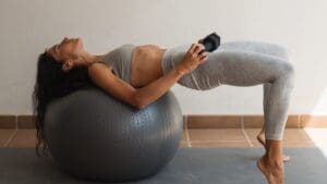 woman on Swiss Ball with dumbbell doing high-intensity low-impact workout