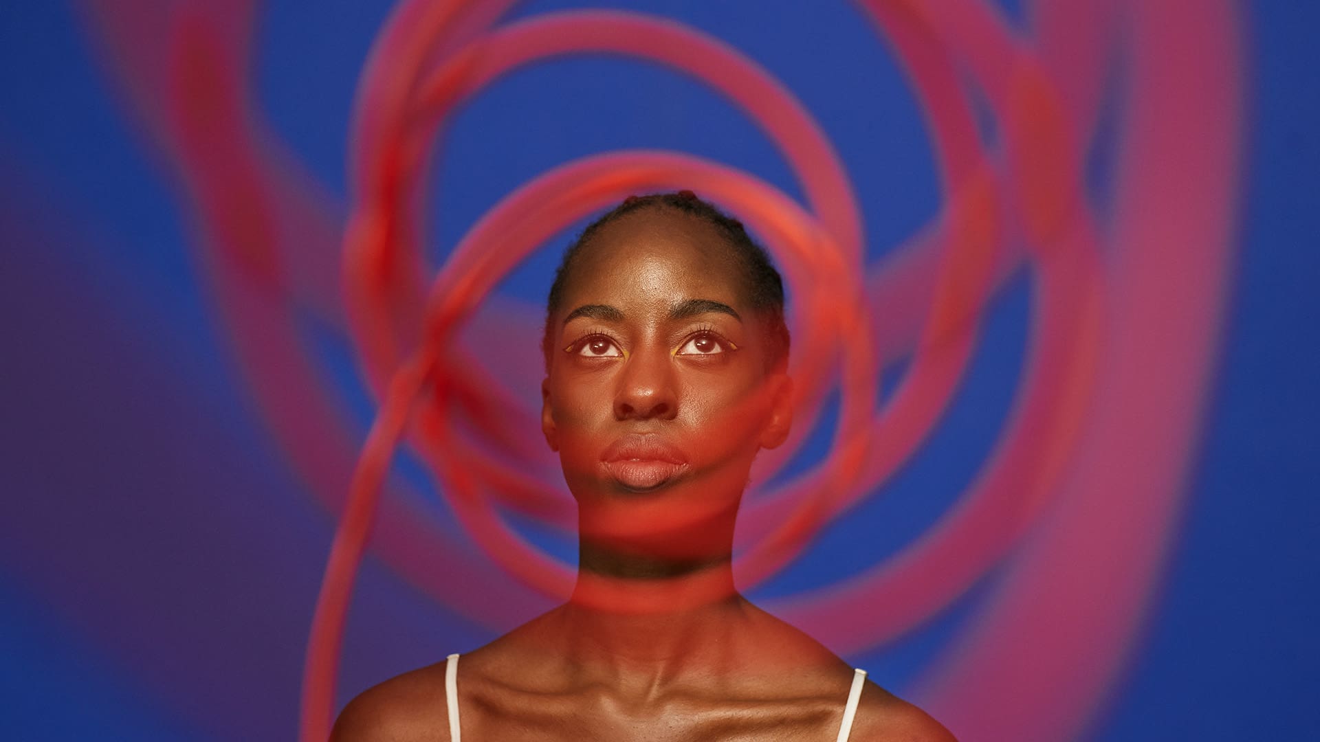 Woman standing behind red cables, thinking