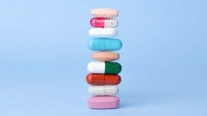 Assorted pills, vitamins and supplements balancing on each other