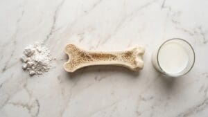 marble counter with glass of milk, dissected bone and white powder