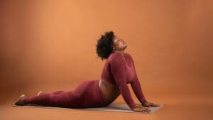 Woman in burgundy activewear doing yoga poses to beat burnout
