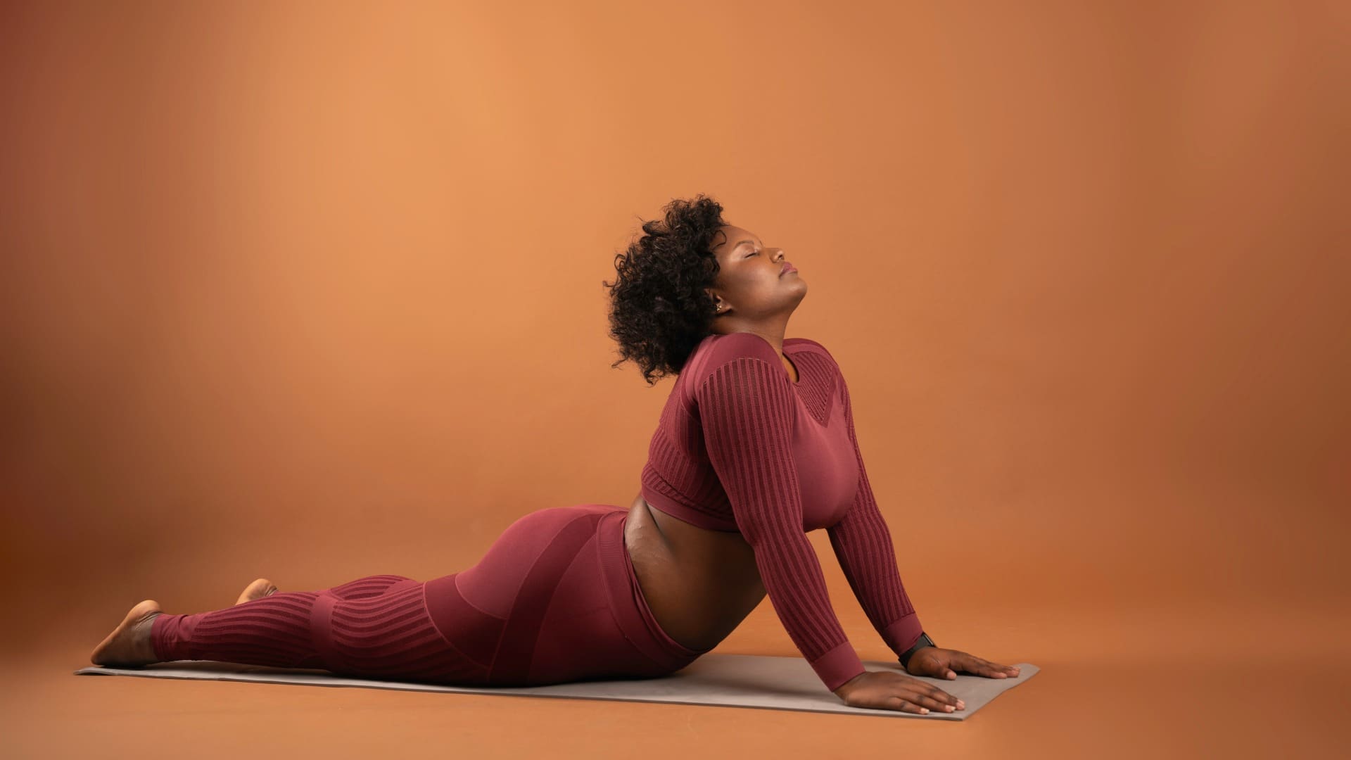 Women’s Health SA-Quick Yoga Poses To Beat Burnout Woman in burgundy activewear doing yoga poses to beat burnout