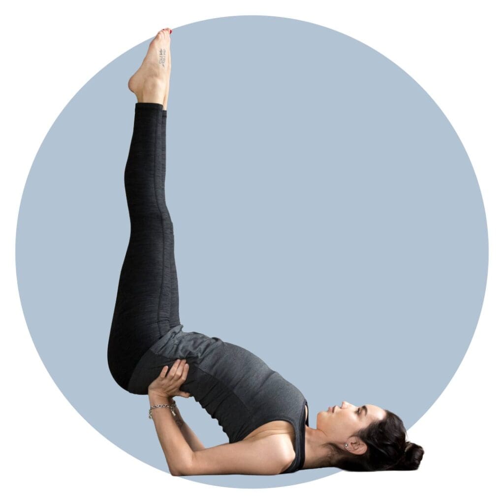 Woman doing feet up yoga pose to beat burnout wearing grey activewear